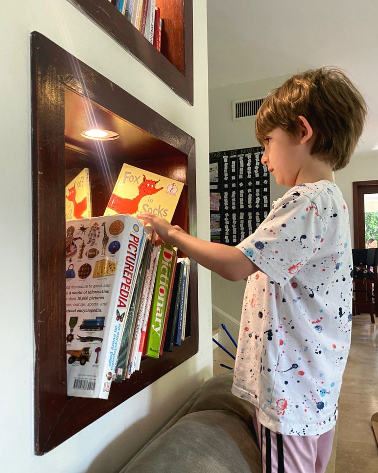 Alumno explorando libros en UDESYA